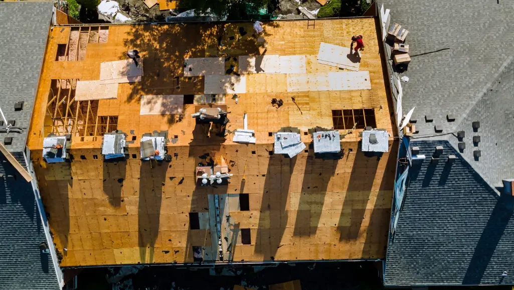 A worker replace shingles on the roof