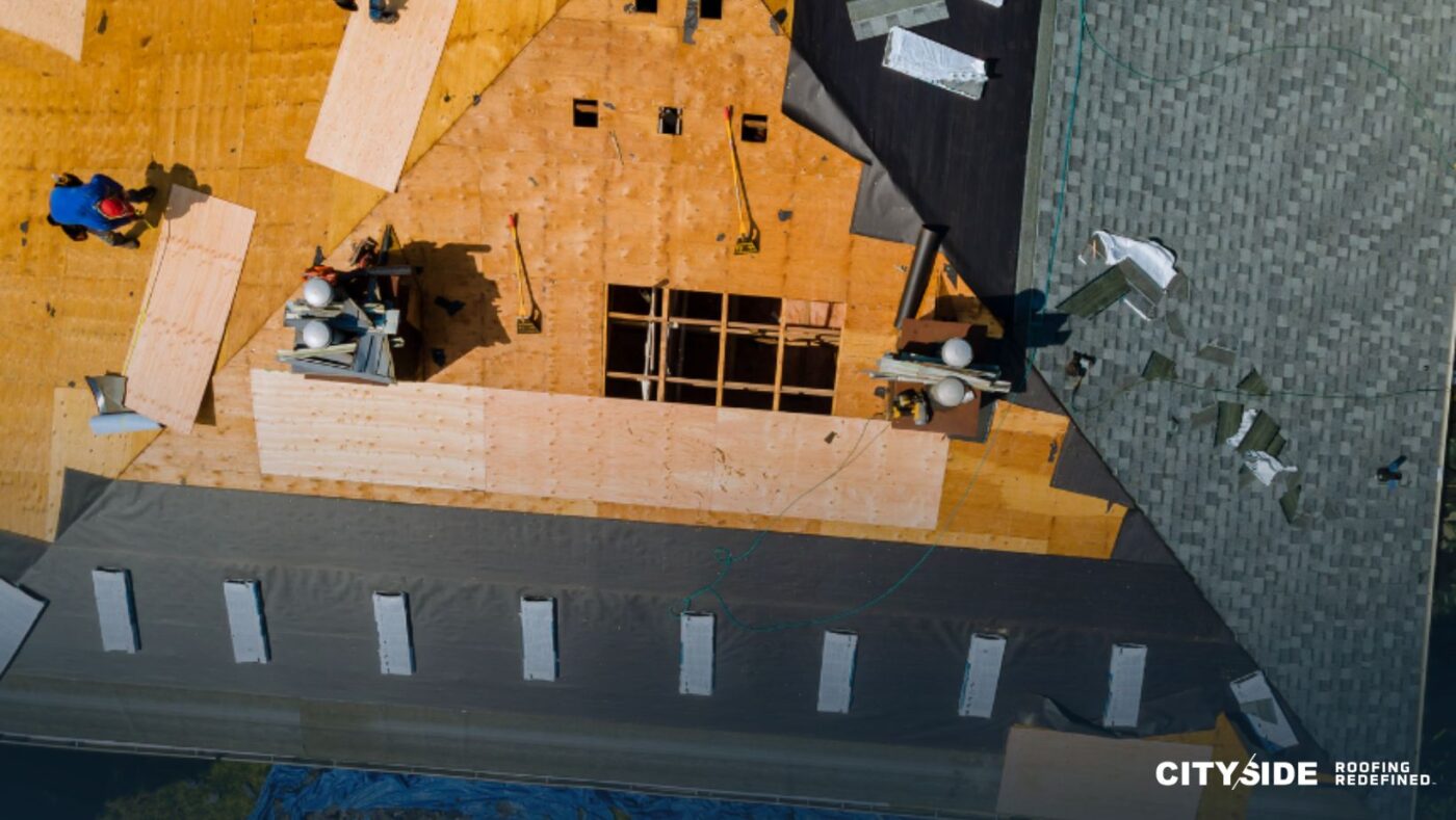 A construction site featuring workers on a roof