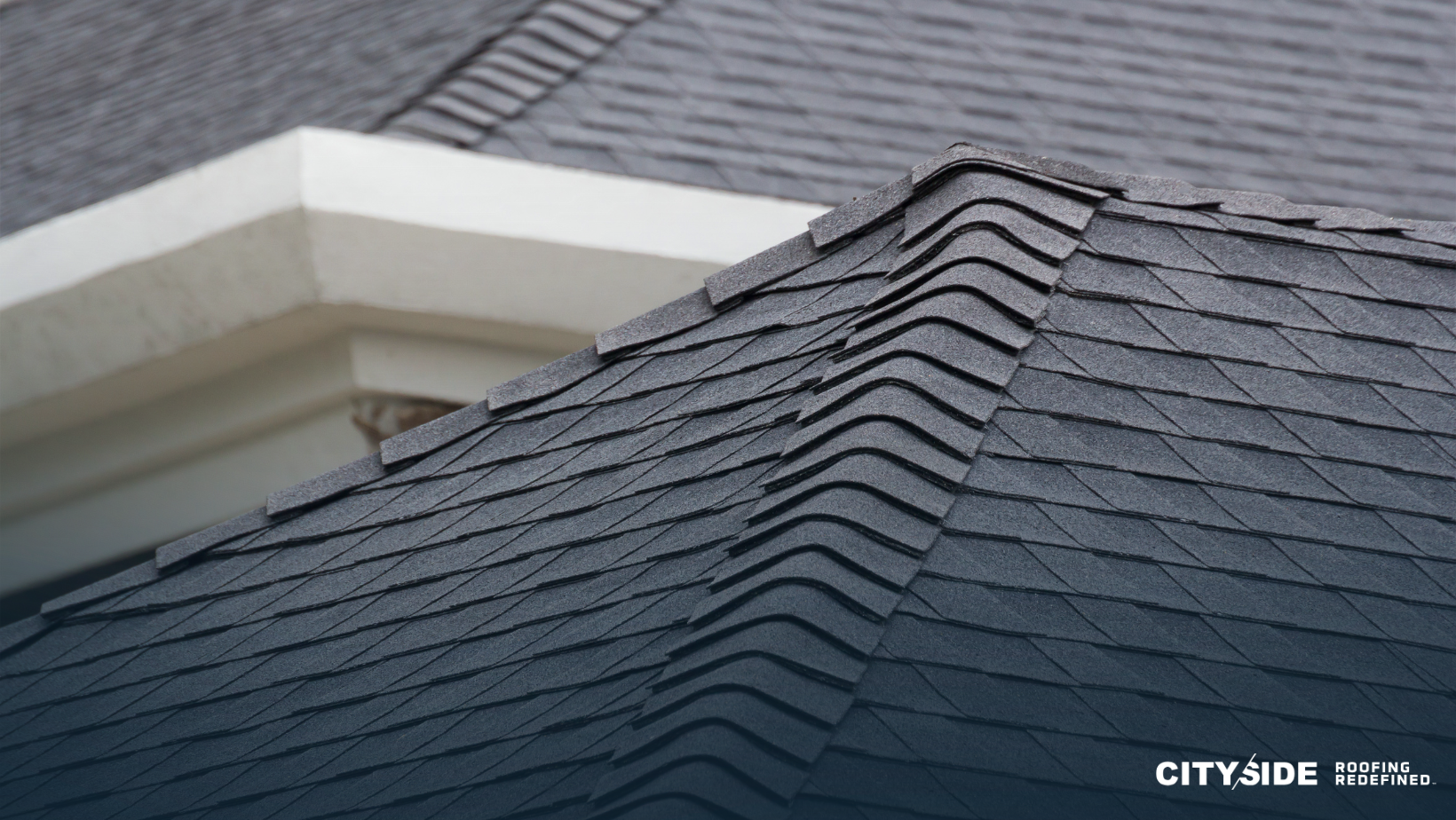 A black shingled roof atop a multi-unit housing structure, showcasing a durable and stylish roofing option.