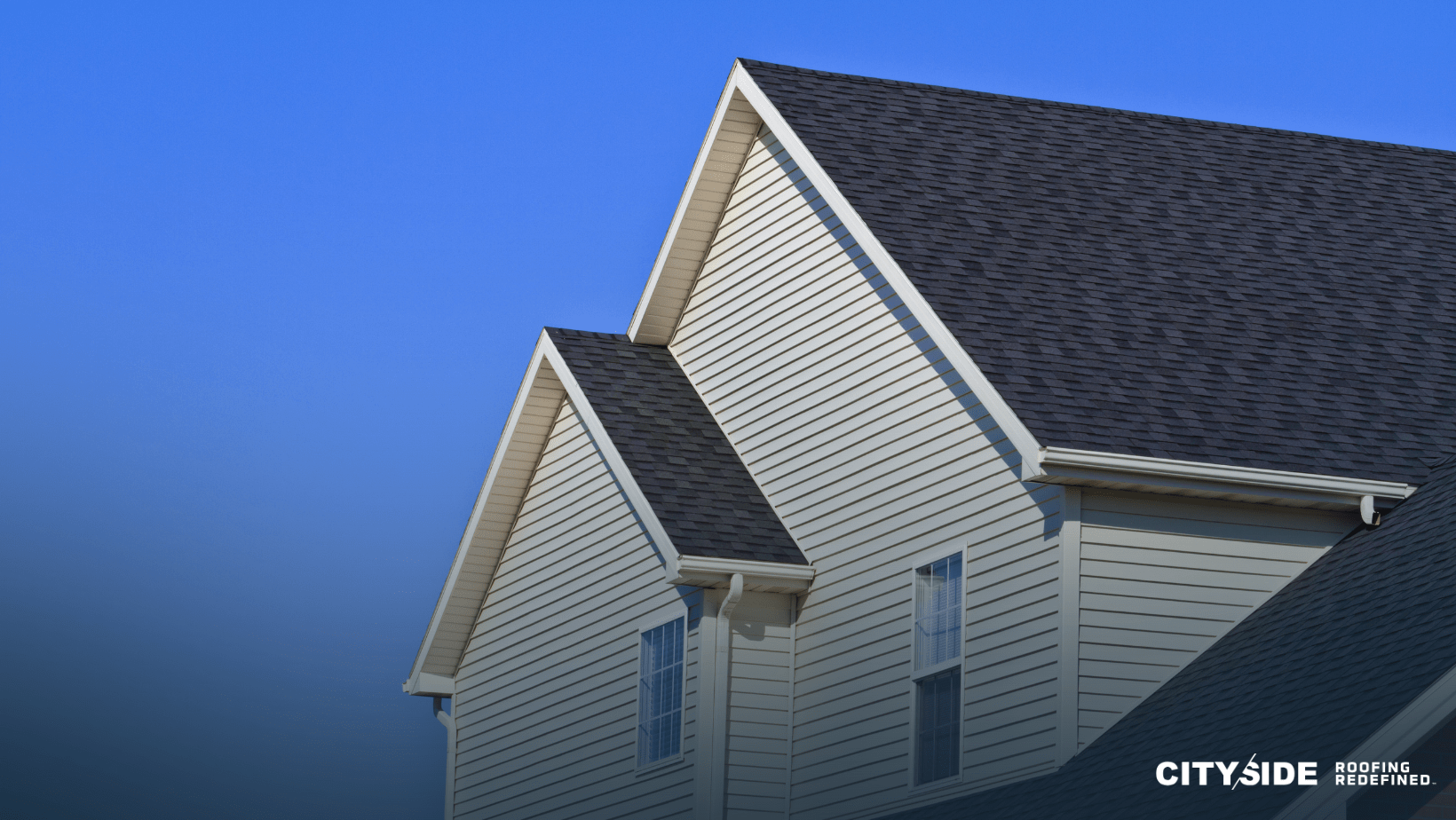  A house featuring a white roof complemented by black shingles, showcasing a classic and elegant architectural design.