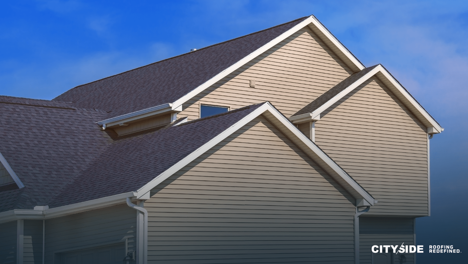 A house featuring a gray roof alongside a contrasting white roof, showcasing a unique architectural design.