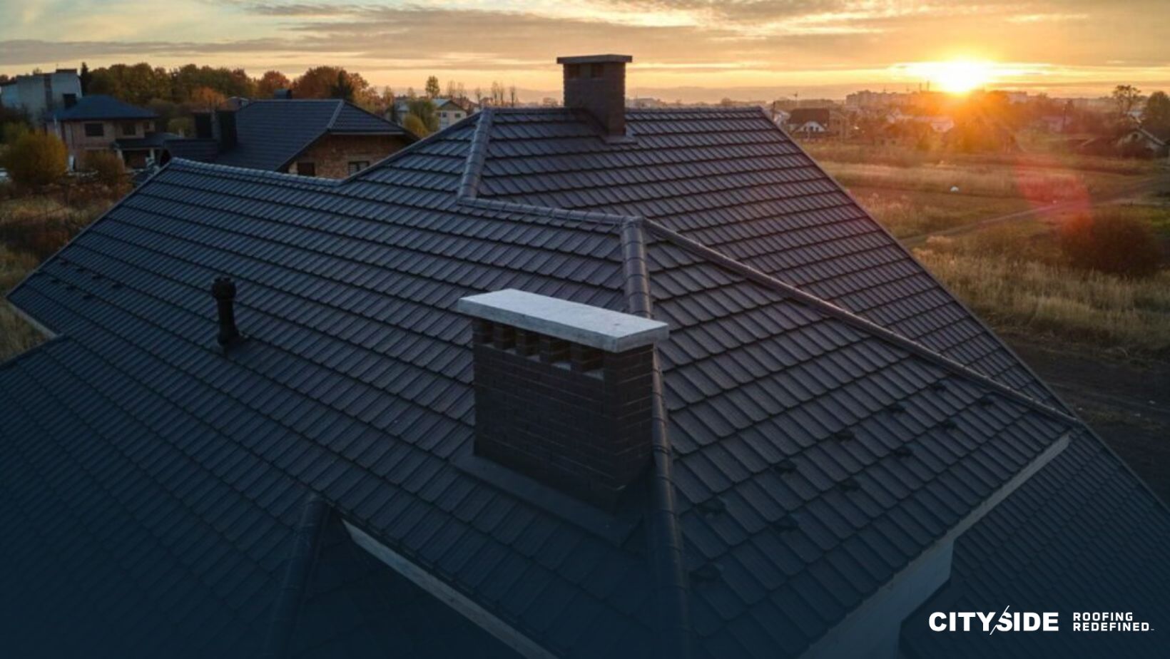 A house roof silhouetted against a vibrant sunset