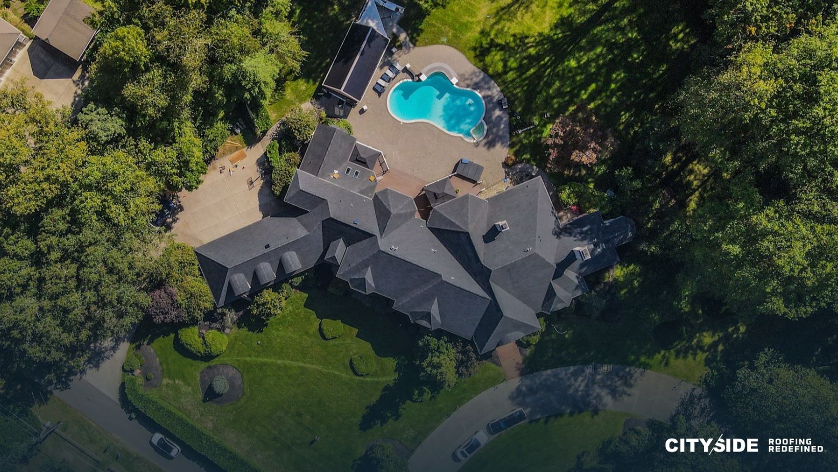 Aerial view of a secluded home surrounded by dense green woods
