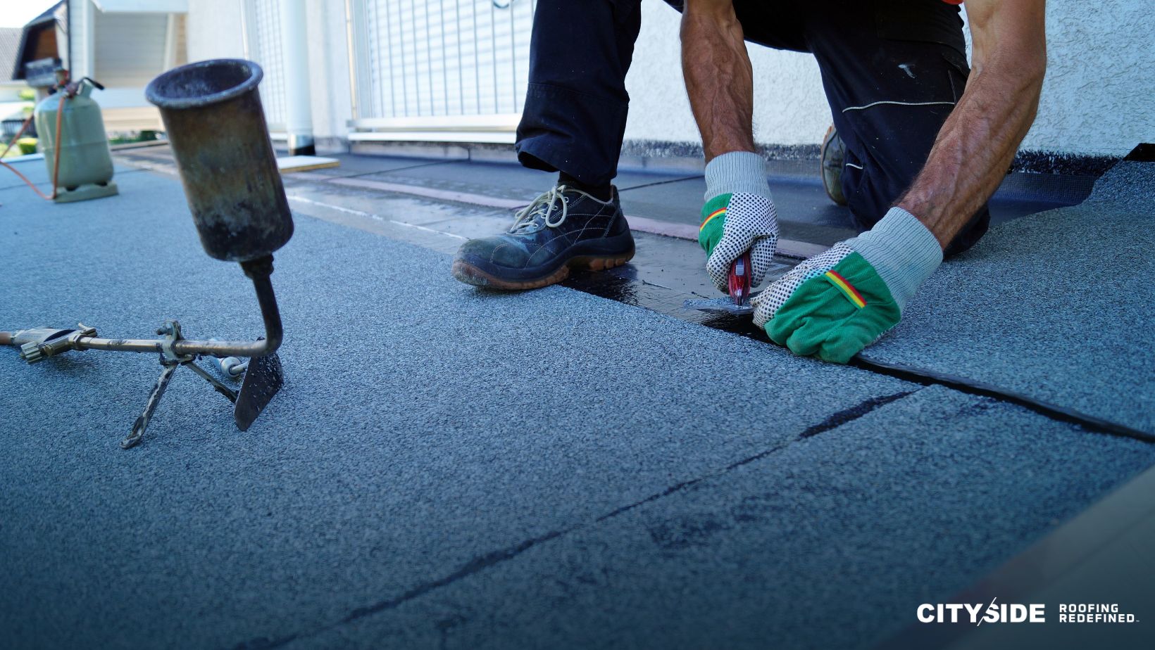 A man is using a tool while working on a roof