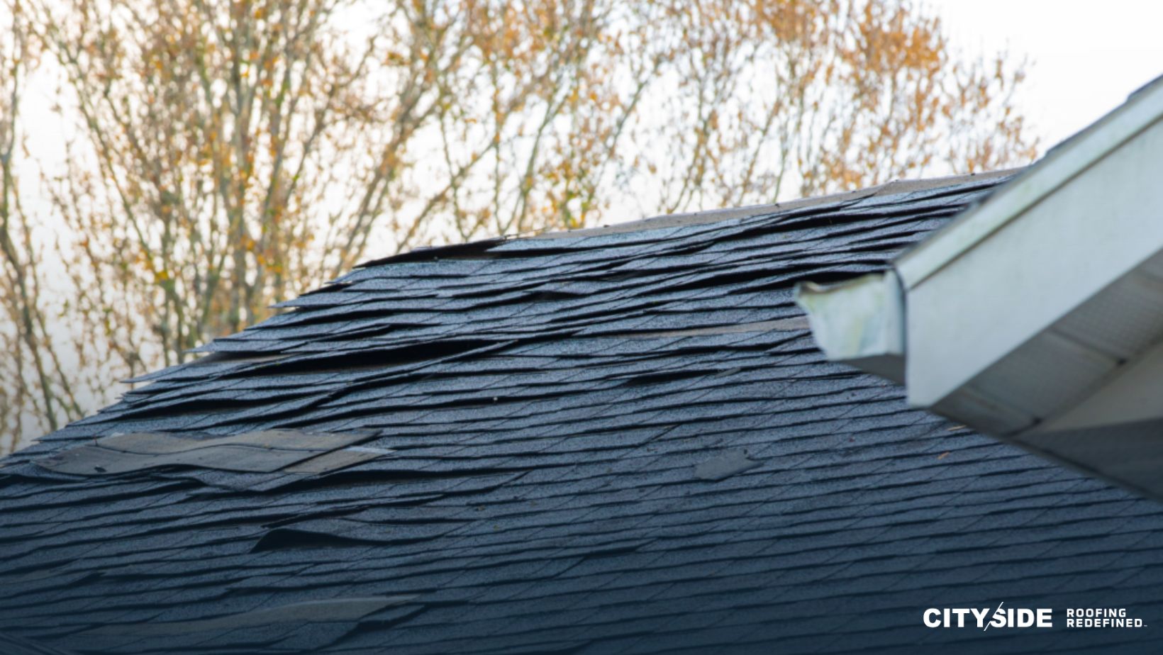 A roof featuring damaged shingles alongside a contrasting white section