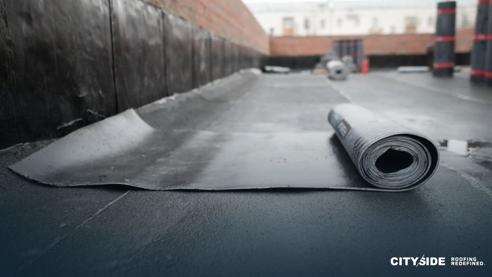 A roll of black rubber is resting on the ground