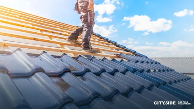 A man stands on the roof of a house