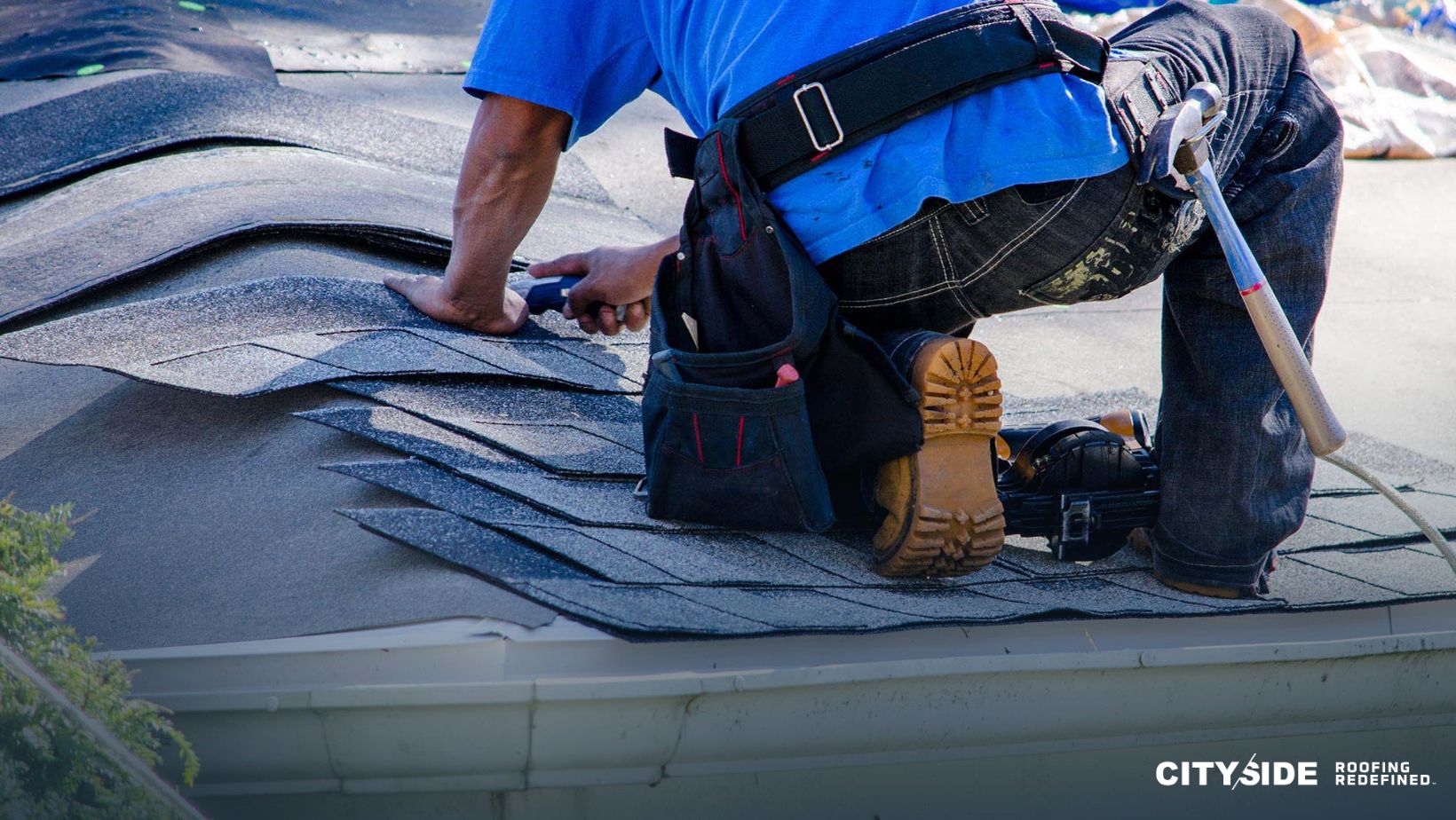 A man is using a tool while working on a roof
