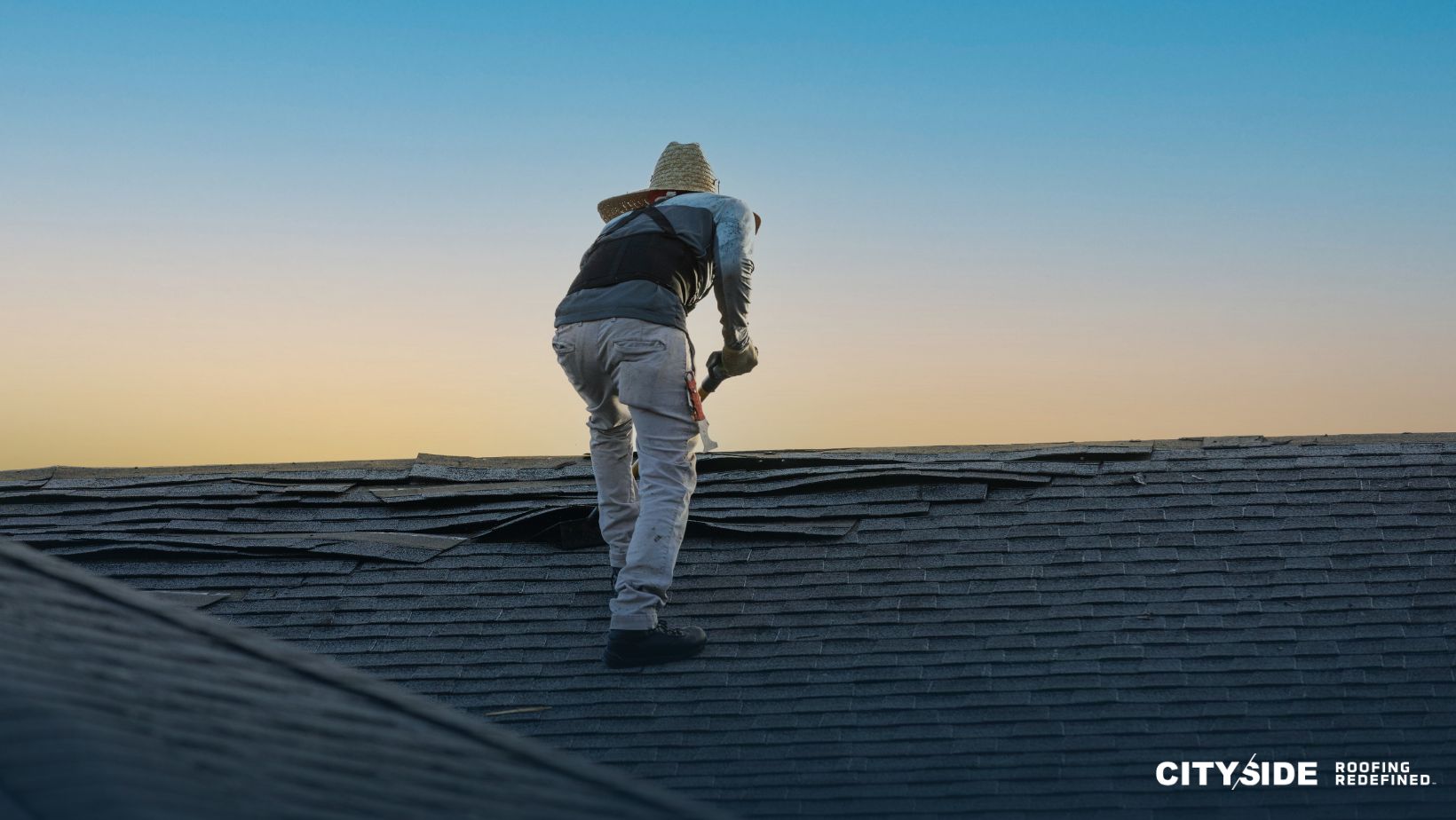 A man wearing a hat stands on a rooftop