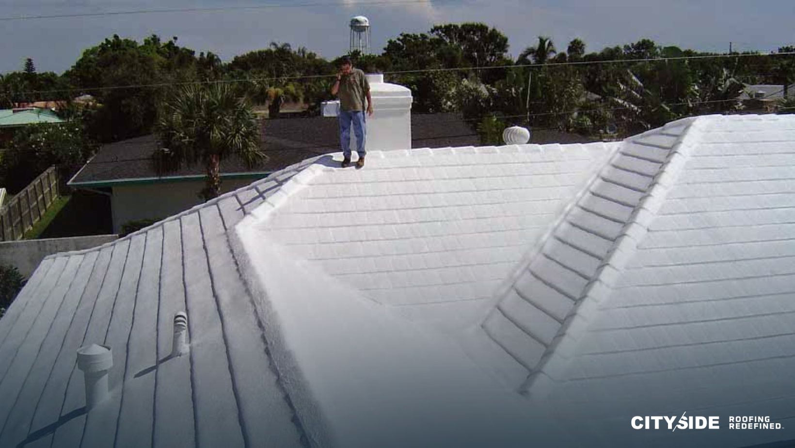 A man stands on the roof of a house