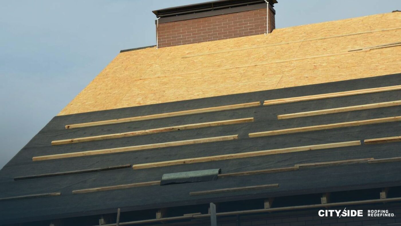 A house roof featuring a prominent chimney at its peak.