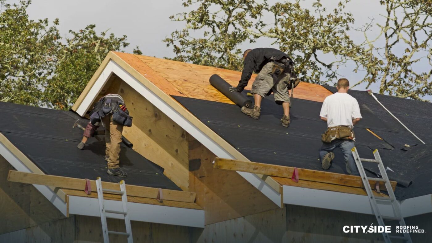 Three men are working on a roof