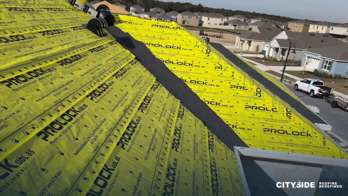 A roofing contractor is working diligently on a sloped roof