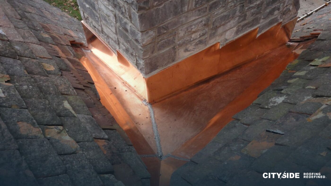 A chimney featuring copper flashing along its side