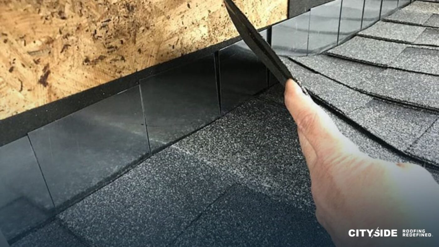 A person cutting shingles on a roof with a knife