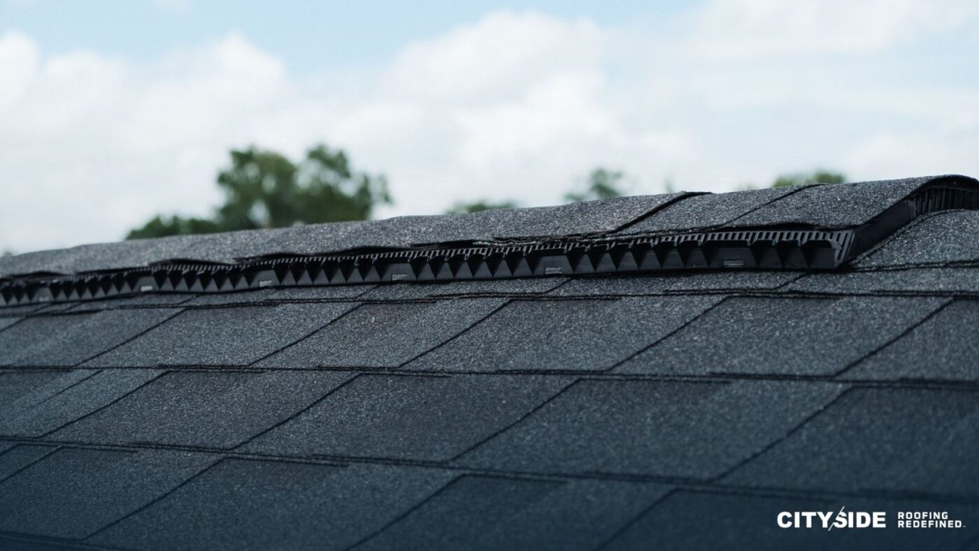 A close-up view of a house roof covered with black shingles