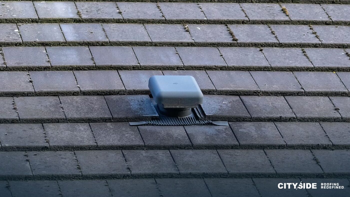 A roof vent positioned on a tiled roof