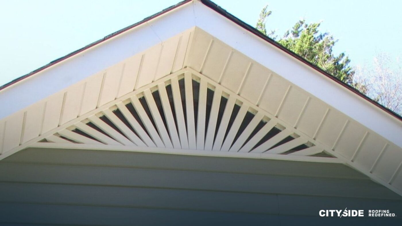 A house roof featuring a window and white siding