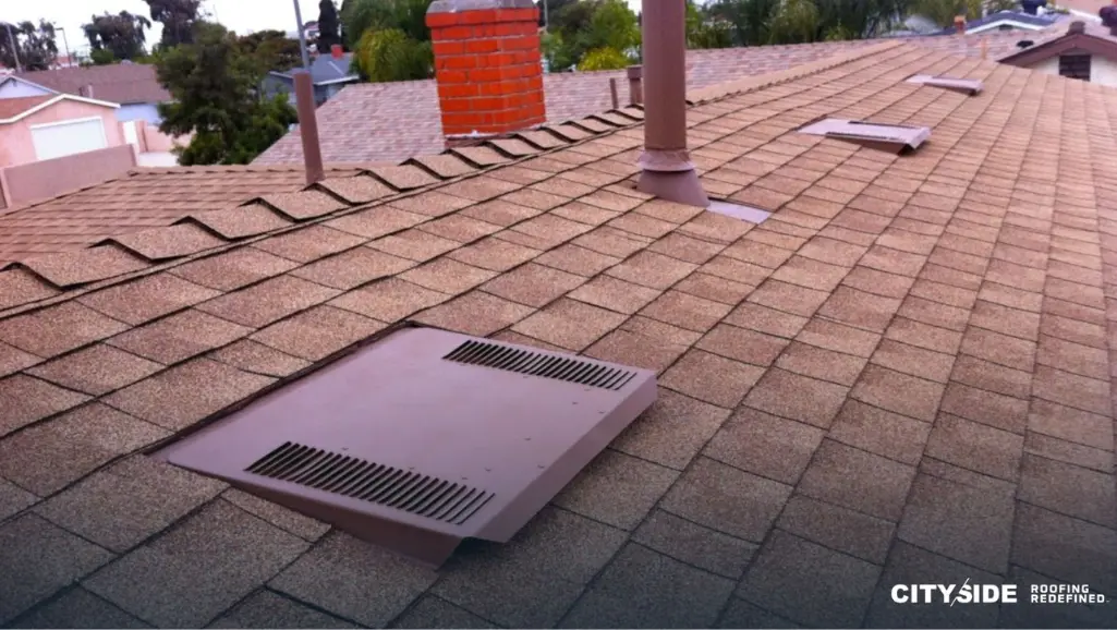 sloped roof with a vent and a brick chimney