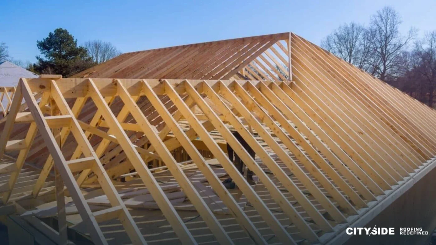 Roof trusses are being installed on a house, showcasing the construction progress of the building's framework.