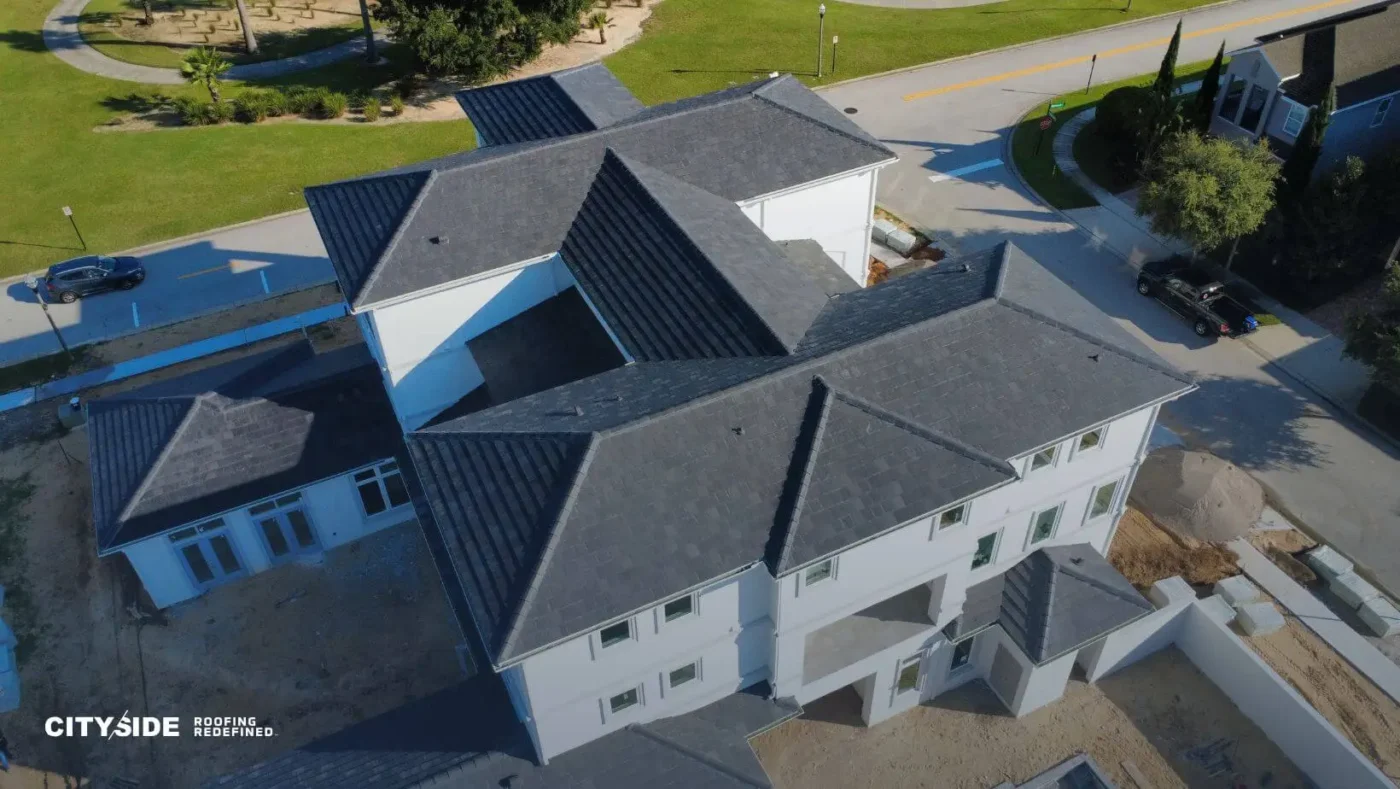 Aerial view of a house showcasing its roof and surrounding landscape.