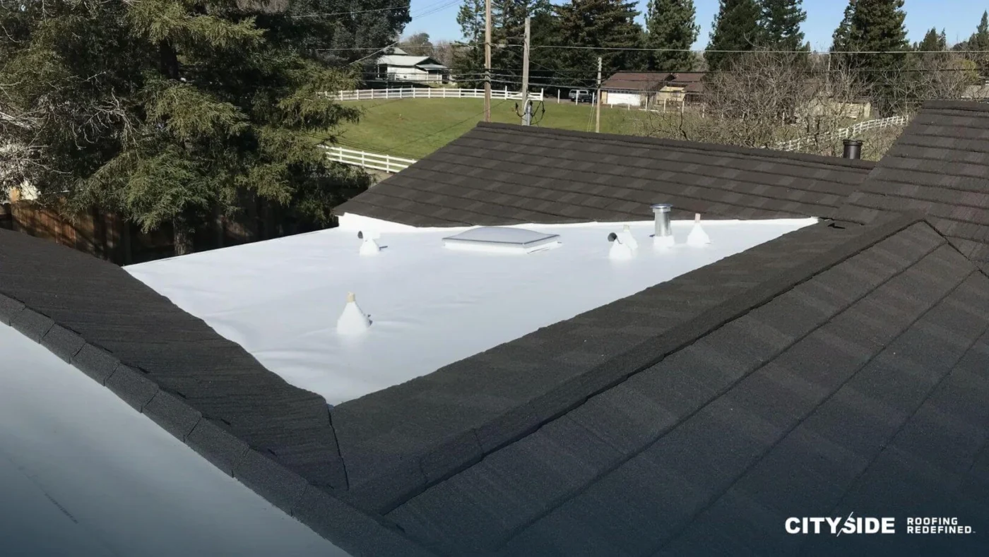 A building roof featuring a section with a white surface and another with a black surface, contrasting in color.
