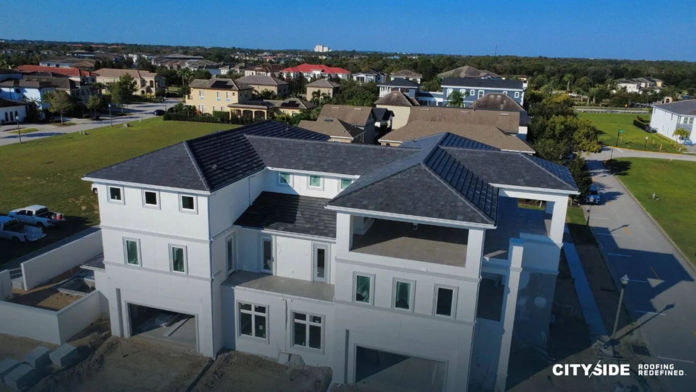Aerial view of a house showcasing its roof and surrounding landscape.