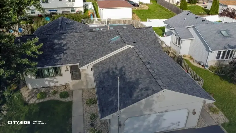 Aerial view of a house showcasing its roof and surrounding landscape.