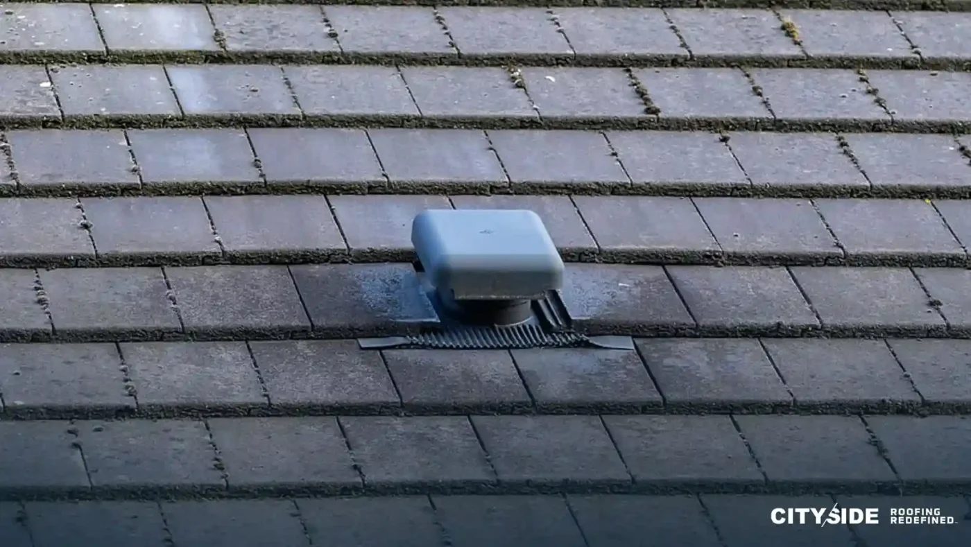A roof vent positioned on a tiled roof
