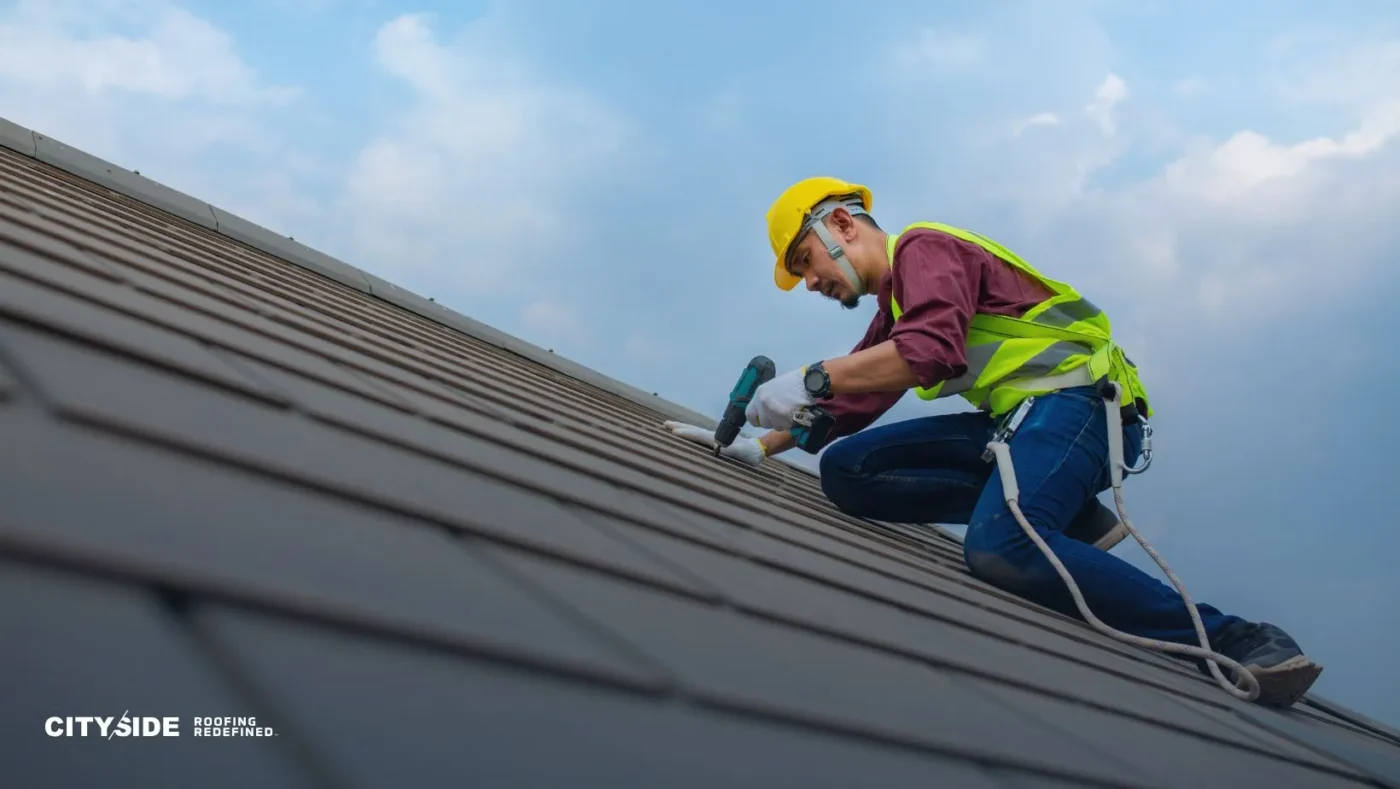 A construction worker in safety gear fixes a roof, wearing a yellow helmet and lime vest, focused, under a bright blue sky. The mood is diligent and professional.