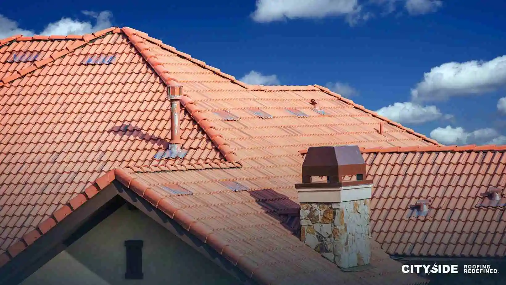 A sloped roof with a prominent chimney and a protective chimney cap
